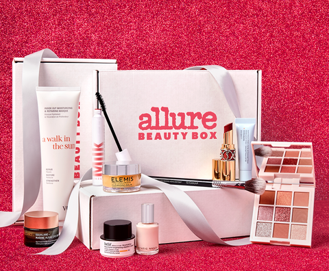 Stack of Allure Beauty Boxes, ribbon and product on a red glitter background